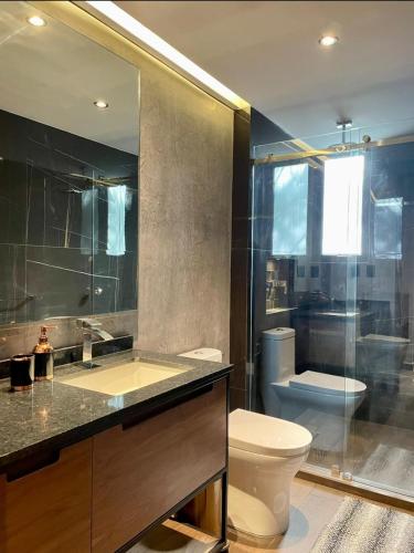 a bathroom with a toilet and a sink and a shower at Suites MINE in Mexico City