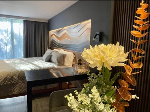 a bedroom with a bed and a table and flowers at BUSINESS SUITES MINE in Mexico City