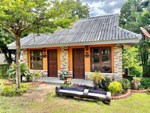 una pequeña casa con un árbol delante en Baanphuthadol, en Mae Hong Son