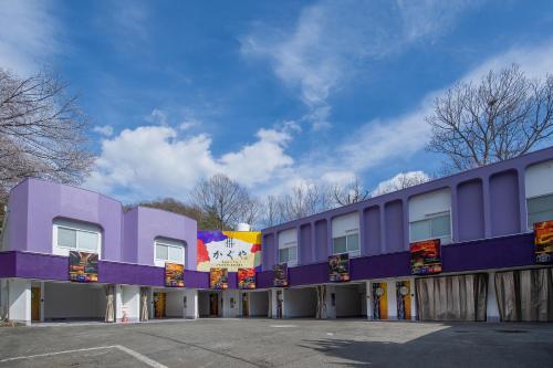 a purple building with a parking lot at Hotel Kaguya in Himeji