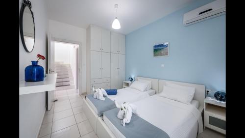 a bedroom with a white bed with towels on it at Xenos Villa 1 With Private Swimming Pool, Near The Sea in Tigaki
