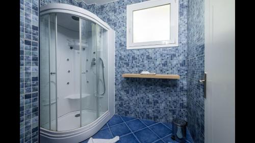 a bathroom with a shower with blue tiles at Xenos Villa 1 With Private Swimming Pool, Near The Sea in Tigaki