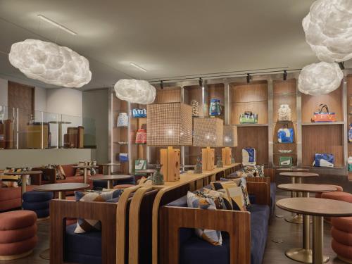 a restaurant with tables and chairs and pendant lights at Public House Bangkok, a Member of Design Hotels in Bangkok