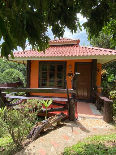 a small orange house with a bench in front of it at Baanphuthadol in Mae Hong Son