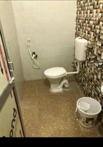a small bathroom with a toilet and a bucket at Hotel Bobby house 450m from beach & 1 km from temple in Puri