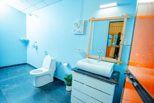 uma casa de banho azul com um WC e um lavatório em orange sky beach bungalow em Agonda