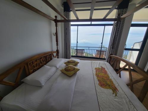 a bedroom with a bed with a view of the ocean at Leisure Mount Villa in Haputale