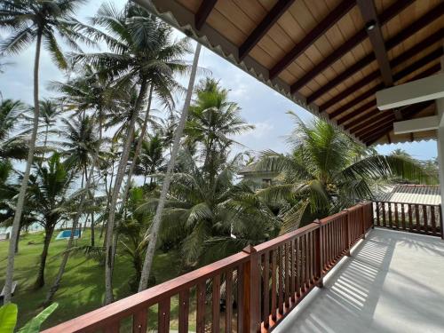 a balcony of a house with palm trees at Galawatta Beach Resort in Unawatuna