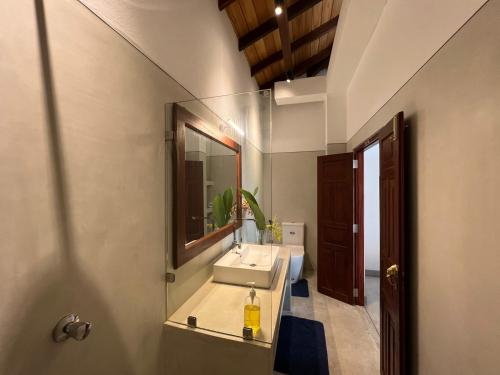 W łazience znajduje się umywalka i lustro. w obiekcie Galawatta Beach Resort w mieście Unawatuna