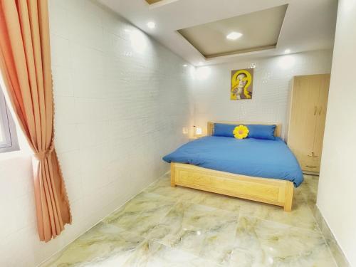 a bedroom with a blue bed in a room at Vĩnh Hà Motel in Trai Mat