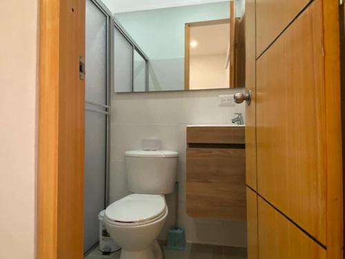 a small bathroom with a toilet and a mirror at Casa Hawai in Melgar