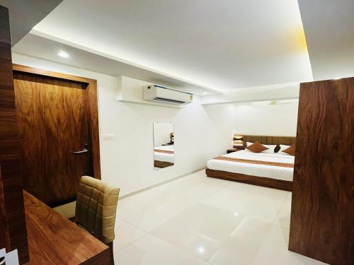 HOTEL BLACK BURN في مومباي: غرفة نوم بسرير ومكتب في غرفة