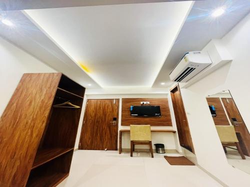 HOTEL BLACK BURN في مومباي: غرفة بها سرير وتلفزيون على السقف