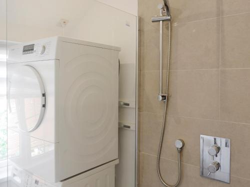 a bathroom with a shower with a washer at Lyndale in Penzance