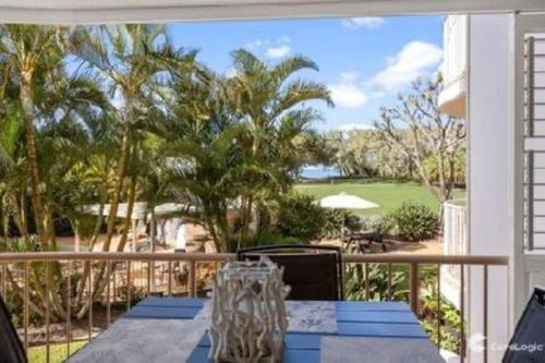 a balcony with a table and a view of a golf course at Kawana Waters Ocean Front Unit-Surfside Resort Sunshine Coast in Buddina