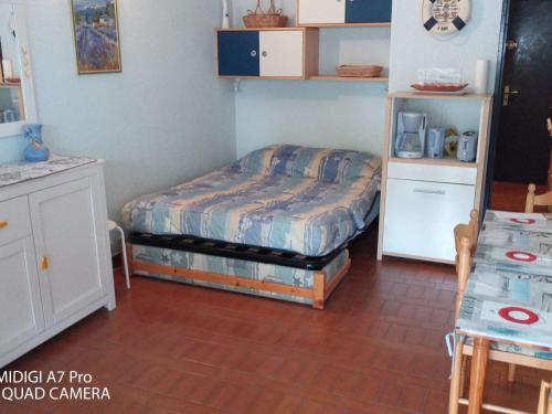 une chambre avec un lit dans une pièce dans l'établissement Studio cosy avec piscine et parking, 4 couchages, proche plage – Le Grau-du-Roi - FR-1-250-196, au Grau-du-Roi