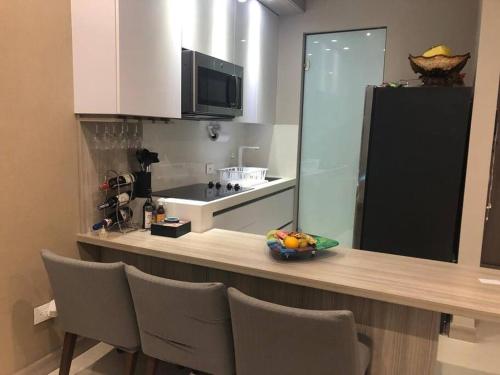 a kitchen with a counter with a bowl of fruit on it at Rams apartasuits en hotel 5 estrellas in Barranquilla