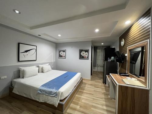 a bedroom with a bed and a desk and a television at The Beach Front Resort, Pattaya in Pattaya