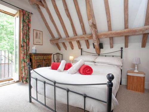 a bedroom with a bed with red pillows on it at The Old Forge in Bleadon