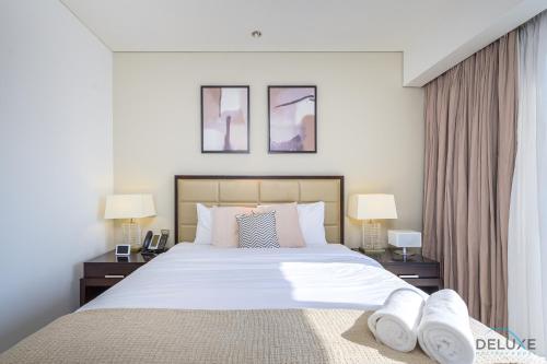 um quarto com uma cama grande e 2 candeeiros em Ornate 1BR in The Address Residences Dubai Marina by Deluxe Holiday Homes em Dubai