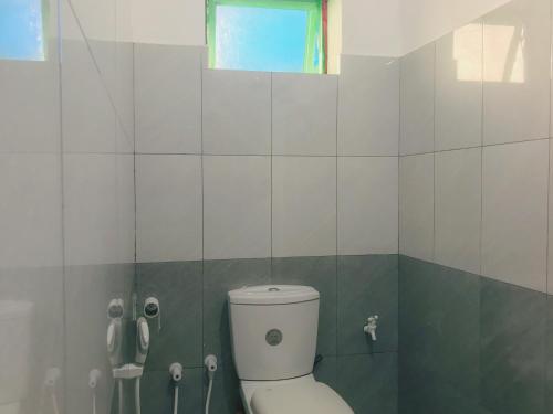 a bathroom with a toilet and a window at Sahana Sri Villa in Bentota