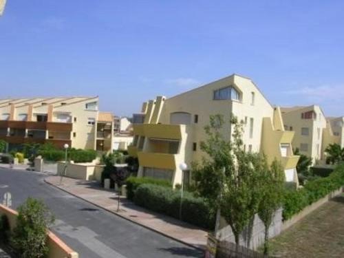 un bâtiment situé dans une rue à côté d'une route dans l'établissement Studio Grand Confort, 4 Couchages, Accès Direct Plage - FR-1-326-593, à Marseillan