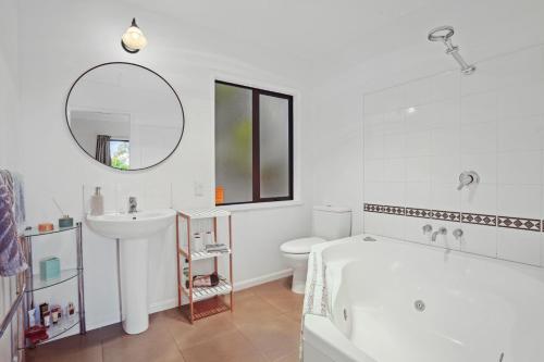 une salle de bain avec une baignoire, un lavabo et des toilettes dans l'établissement Bushside Cottage - Akaroa Holiday Home, à Akaroa