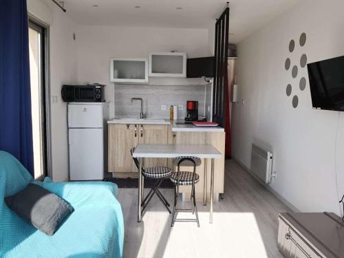 une petite cuisine avec une table et des chaises dans une pièce dans l'établissement Studio moderne, proche plage et commerces, terrasse ensoleillée - FR-1-326-699, à Marseillan