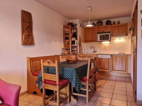 une cuisine avec une table et des chaises dans une pièce dans l'établissement Appartement cosy avec terrasse, proche pistes et commodités - 6 pers. - FR-1-595-37, à Notre-Dame-de-Bellecombe