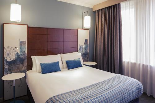 a hotel room with a bed and two lamps at Mercure Bristol Holland House in Bristol