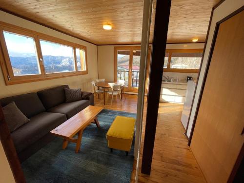 un soggiorno con divano e tavolo di Tamanegi House luxury 4 bedroom Ski Chalet a Nozawa Onsen