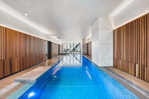 a large swimming pool in a building at Paragon Apartments by CLLIX in Melbourne