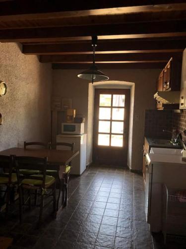 une cuisine avec une table et des chaises et une fenêtre dans l'établissement Petite Maison à la campagne, à Malrevers