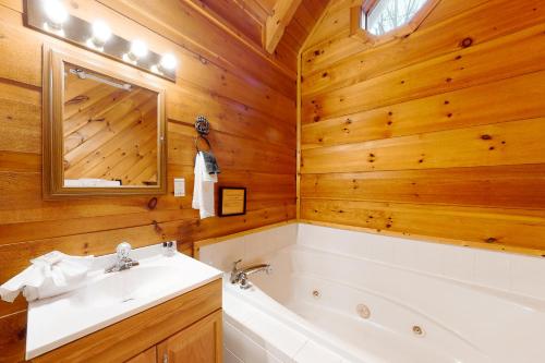 y baño con bañera, lavamanos y bañera. en Misty Mountain Cabin en Gatlinburg