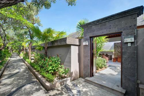 a brick building with an open door and trees at Lumbini Luxury Villas and Spa in Jimbaran