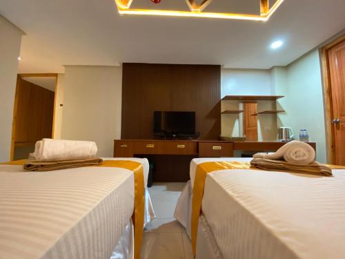 a hotel room with two beds and a tv at NGN Gran Hotel in Tuguegarao City