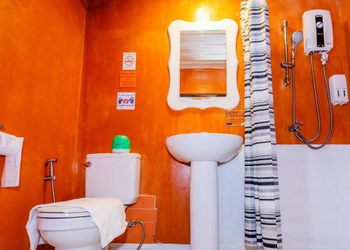 a bathroom with a toilet and a sink at Retro Box Hotel Chumphon in Chumphon