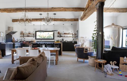 uma sala de estar com uma mesa e uma cozinha em La Grange de Fer I Classée 5 étoiles em Saint-Ferréol-Trente-Pas