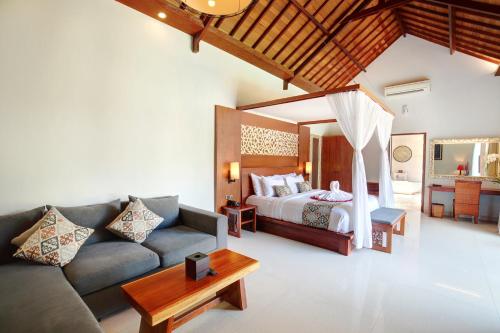a living room with a bed and a couch at Lumbini Luxury Villas and Spa in Jimbaran