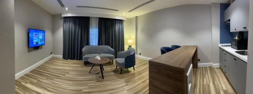 een woonkamer met een tafel en stoelen en een televisie bij Warwick Al Jubail Hotel in Al Jubail