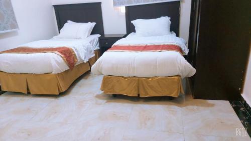 dos camas sentadas una al lado de la otra en una habitación en غرف الصفا الشهري en Jazán
