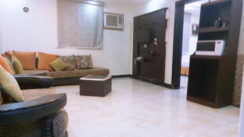 a living room with a couch and a table at غرف الصفا الشهري in Jazan