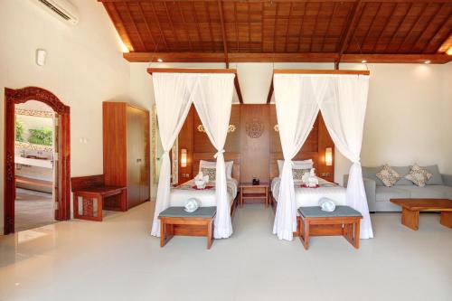 a bedroom with two beds and two tables at Lumbini Luxury Villas and Spa in Jimbaran