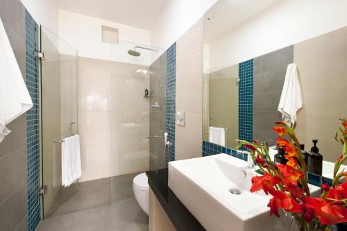 bagno con lavandino, servizi igienici e specchio di The Beach Apartments a Negombo