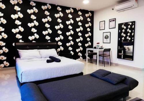 a bedroom with a black wall with white flowers on it at Peanut Butter Homestay #Trefoil Setia City in Setia Alam