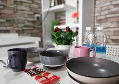 a kitchen counter with three bowls and bottles of water at Peanut Butter Homestay #Trefoil Setia City in Setia Alam