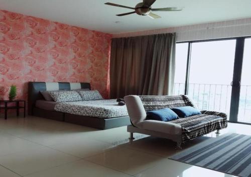 a bedroom with a bed and a chair and a fan at Peanut Butter Homestay #Trefoil Setia City in Setia Alam