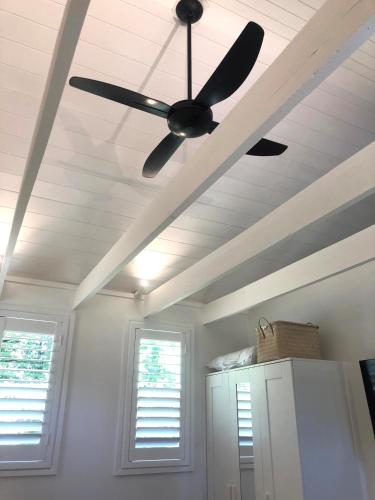 a ceiling fan in a kitchen with two windows at The Stables in Armidale