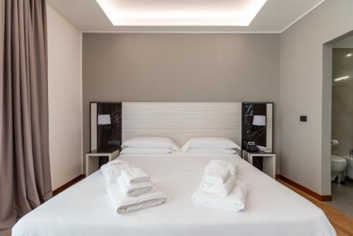 a bedroom with a white bed with towels on it at Sestante Marina Motel in Capo dʼOrlando