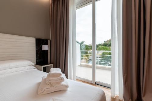 a hotel room with a bed and a large window at Sestante Marina Motel in Capo dʼOrlando